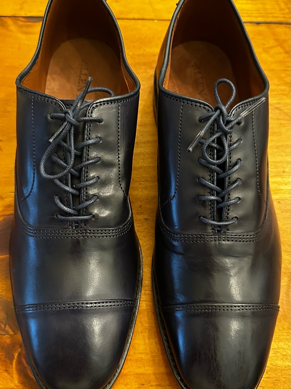 Allen Edmonds Park Avenue cap toe oxfords in dark blue with black soles.